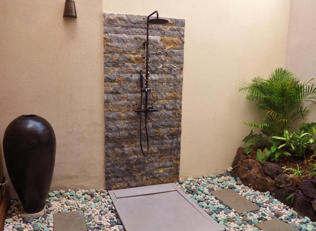 Douche extérieure en pierre dans un patio zen