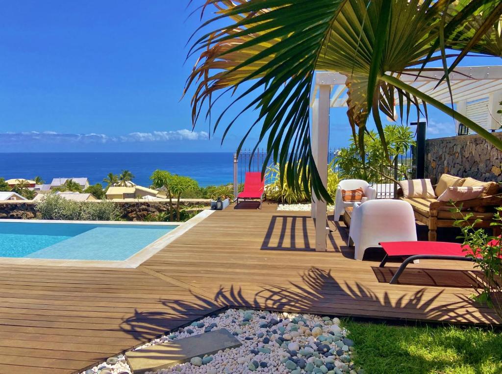 Terrasse en bois avec mobilier et palmiers face à l'océan